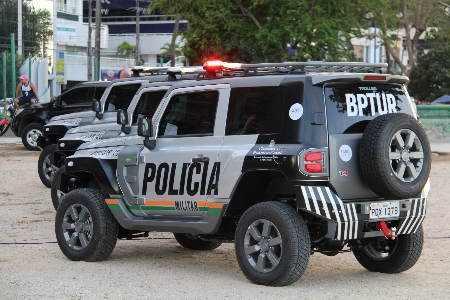 Viaturas do Batalhão de Policiamento Turístico (BPTur) adesivadas com a nova comunicação visual do Governo do Estado. Os veículos estão alinhados na areia da Praia do Mucuripe, em Fortaleza